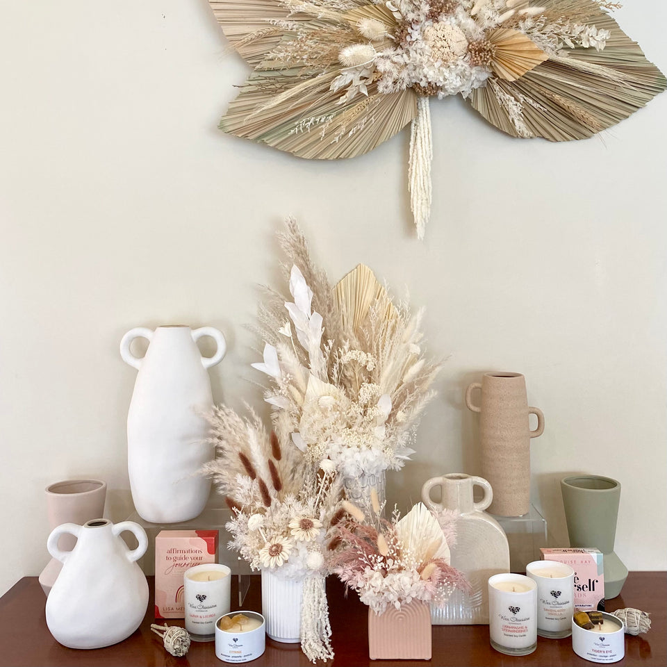 Vases, Dried flowers and candles sitting on a side board
